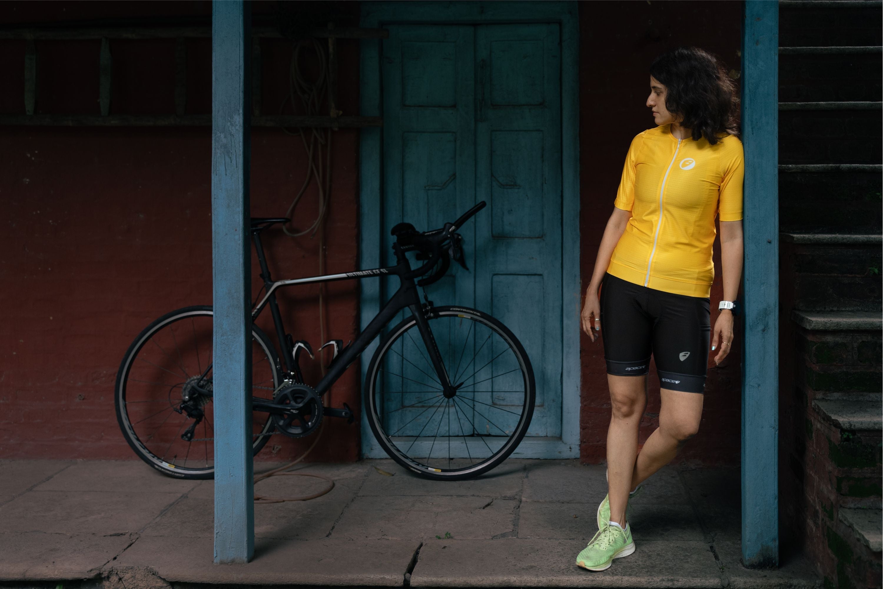 A women staring at her cycle and wearing yellow cycling jersey